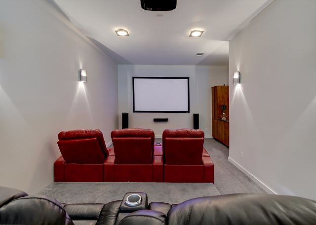 Have a fun family movie night in this media room with recliner seats and large projector screen