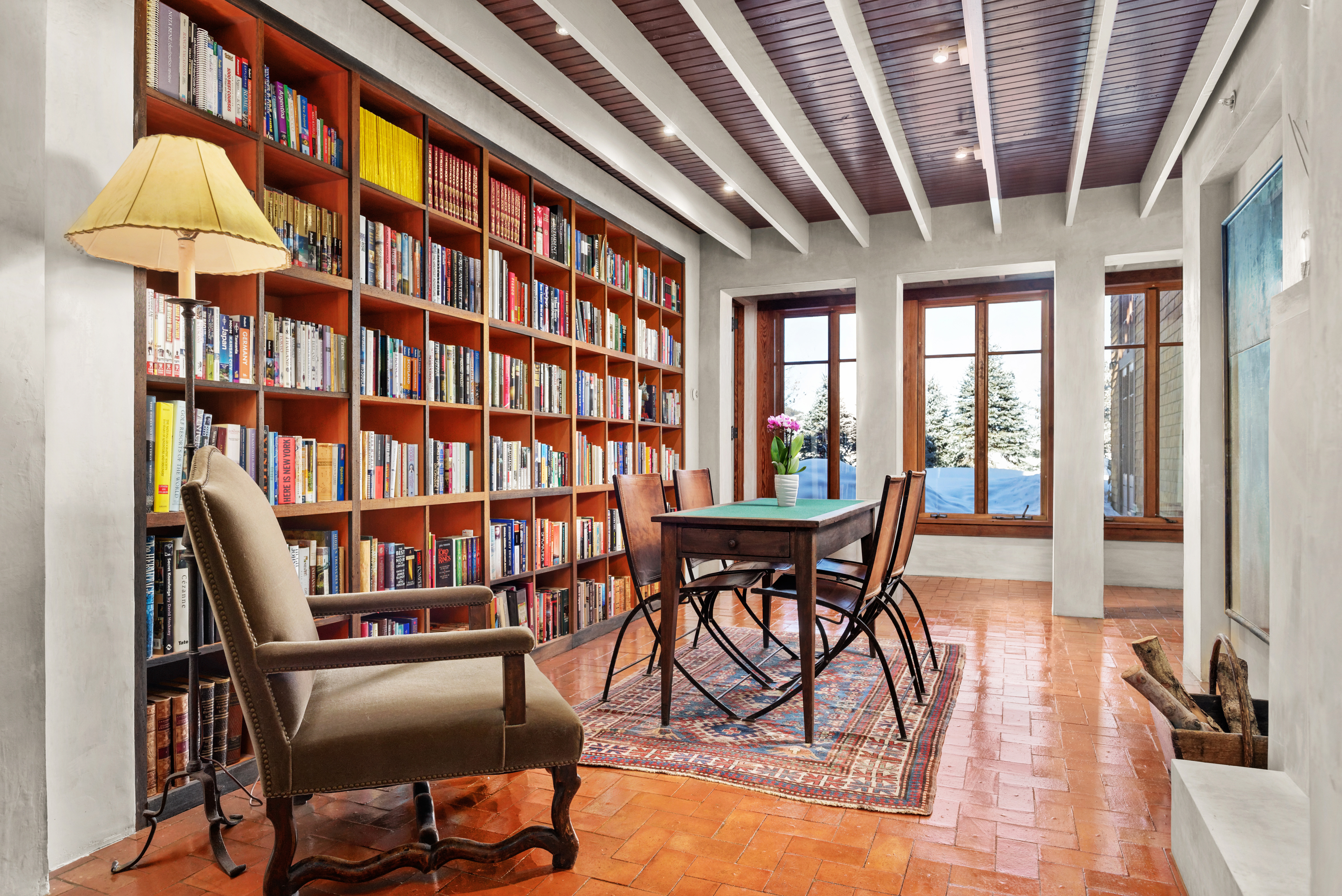 Library with seating and floor to ceiling windows for natural light. 