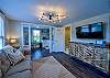 The living room in this apartment has a comfy couch and large tv.