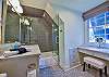 The bathroom is attached to the upstairs bedroom and has a tub-shower and vanity for getting ready in the morning.