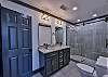 The attached bathroom has a walk-in shower and double sink vanity.
