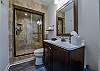 The bathroom in the hallway has a walk-in shower.