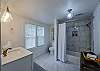 The first bathroom is attached to the king bedroom. It has a shower-tub. 