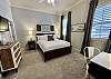 The second bedroom has ma queen bed, desk and tv.