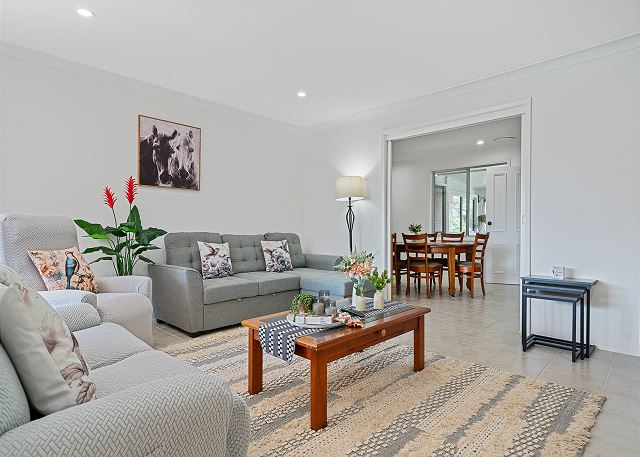 Comfy living room with plenty of seating, smart TV and games.