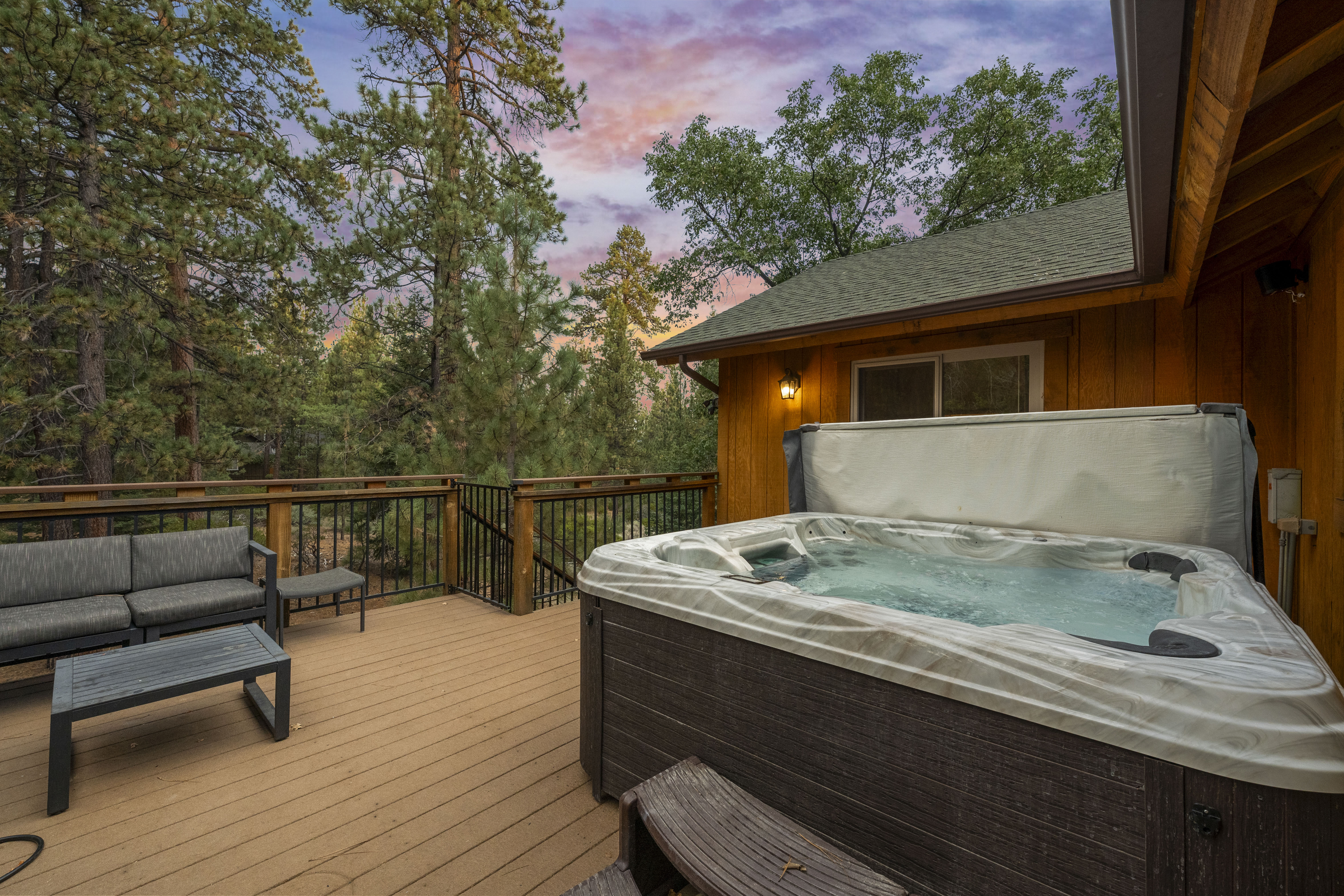 Back Deck with Treetop views and walking trail into the village. Private hot tub, fire pit, and comfy seating