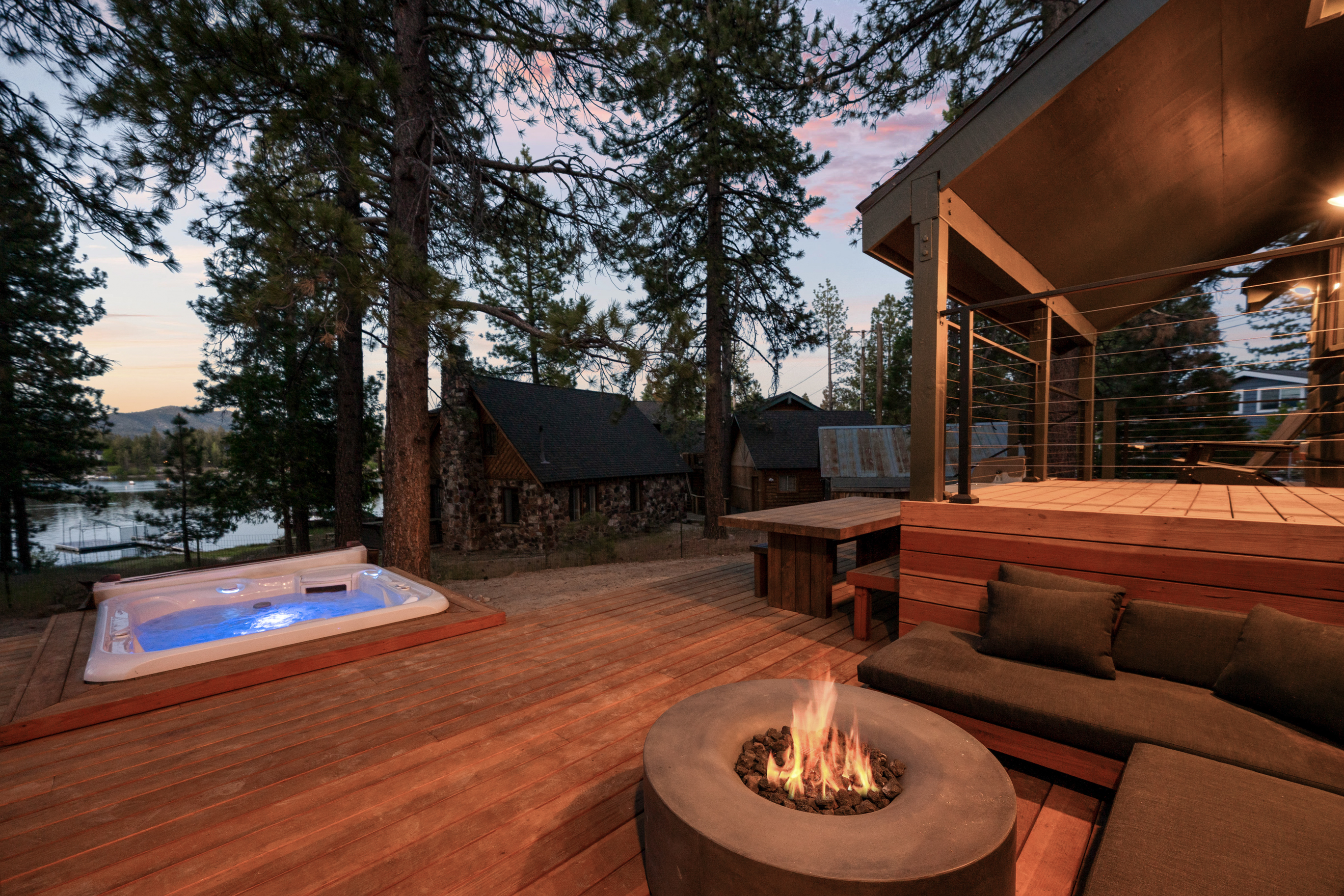 Outdoor Wellness Retreat Lakefront - Expansive deck with hot tub, sauna, lakefront views, fire pit, and comfy seating areas.