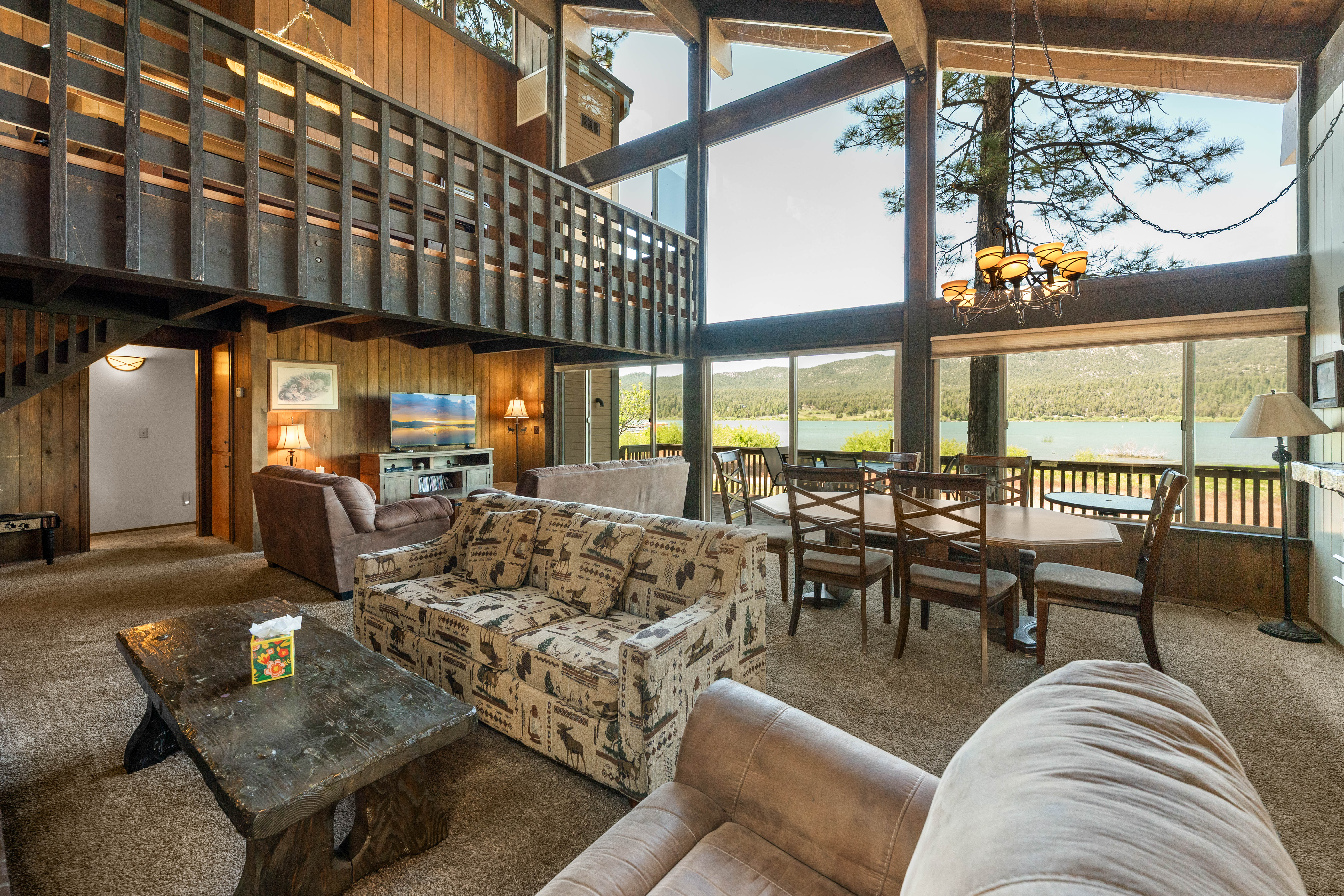 Living Room with smart TV, wood fireplace, comfy couches, and vaulted ceilings.