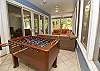 Main level screened in porch with foosball table 