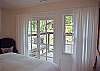 Main Level Bedroom is bright and airy, with private balcony overlooking the lake and pond spillway into Lake Lure
