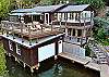 Large boathouse deck has lounge chairs, sun umbrellas, covered seating area, gas BBQ grill and dining table for 6