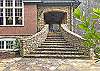 Patio stairway takes you down to stone terraces, boat house, parking, and outdoor fireplace area.