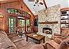 Great Room has large stone fireplace (gas), TV and plenty of comfy seating.  Doors open onto Upper Level Deck.