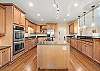 Kitchen has large island with gas cooktop, built-in double ovens, 2 sink areas and plenty of work-space and serving areas.