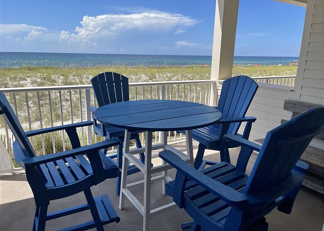 A Polywood dining table and chairs provides a prime space for dining overlooking the emerald green Gulf of Mexico waters.