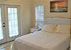 Queen-sized bedroom with doors out to a small front balcony