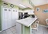 The kitchen of this one-bedroom unit has several nice features, including tiled countertops, Mr. Coffee and Keurig coffee makers and two-sided sink with pull out sprayer. 3 chairs at the island provide additional seating