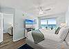 Facing a flat screen TV with a private bathroom to the side