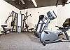 The fitness room features a spin bike, treadmill, and more.