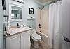 This guest bathroom is softly decorated & equipped with the usual features. 