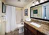 An elegant bathroom for the guests.  A nice big mirror with very good lighting. 