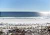 A great picture of the beach as the sun shines across the water. 