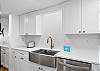 A beautifully designed open kitchen with crisp white cabinetry and stylish countertops.