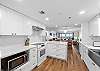 Bright and airy open kitchen featuring stunning white cabinets and countertops.