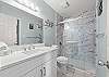 Accessible from the hallway and guest bedroom, the second full bath also has a step in shower.