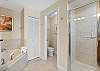 Relax in a spa-like master bath featuring a jetted tub and separate walk-in shower—perfect for unwinding after a beach day.