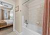 Spacious shower, tiled floors, and private entrance to the second guest bedroom