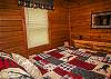Featuring log furniture and cabin decor, the main level bedroom adds to the cabin feel found throughout Quiet Splendor.