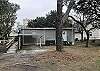 Back of home with one covered parking and handicap ramp access