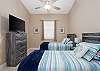 3rd Bedroom showcases 2 Twin Beds with Beach Blue Hues and TV.