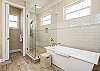 Top Floor Master Bathroom features soaking tub and separate shower to decompress from a day at the beach.
