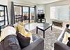 Spacious living room with open floor plan and connected balcony featuring a direct view of the ocean.