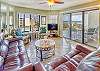 Spacious living room with open floor plan and connected balcony featuring a direct view of the ocean.