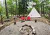 Tipi campsite with tiki torches and fire pit