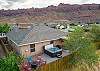 Fully fenced backyard has private hot tub, gas firepit, grill and covered outdoor dining table with ambient lighting. Take in the dramatic views of the Moab Rim while you soak!