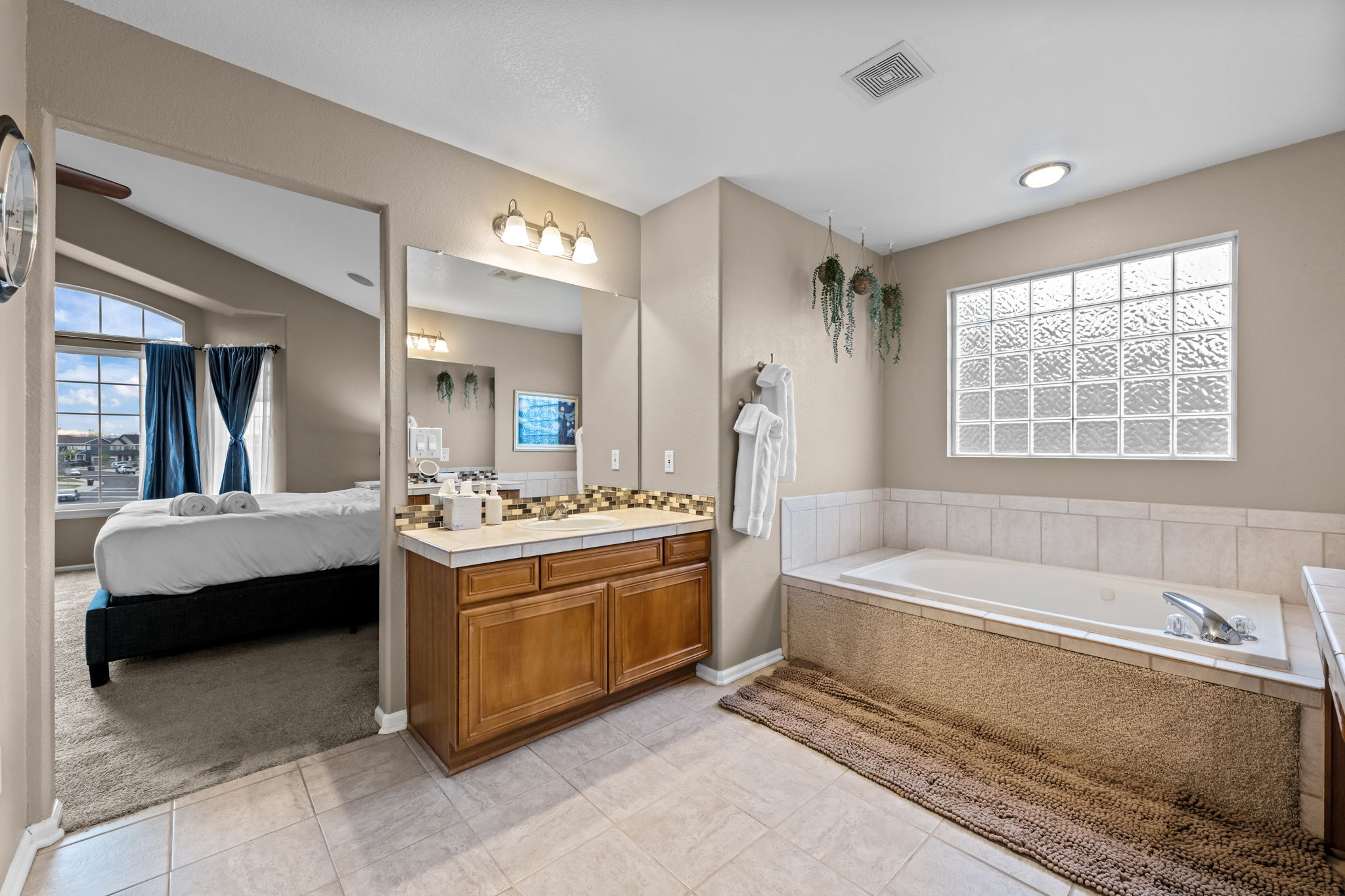 Primary bathroom ensuite with two separate sinks, bathtub with jets, and separate shower
