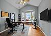 Office with stationary bike, large writing desk, TV, and stereo/record player