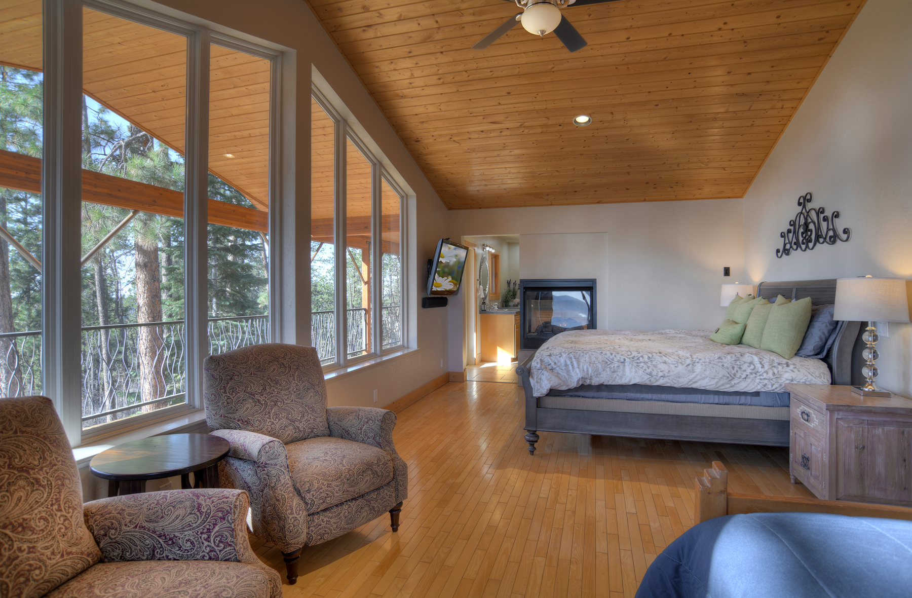 Master bedroom with king bed, ceiling fan, gas fireplace, TV and deck.