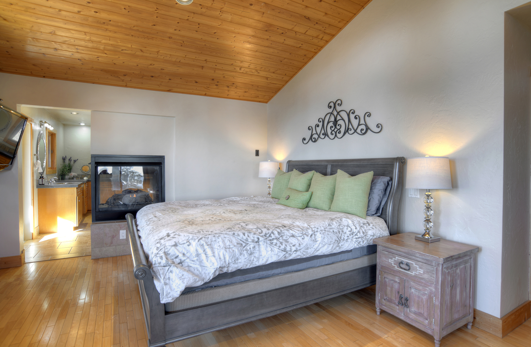 Master bedroom with king bed, ceiling fan, gas fireplace, TV and deck.