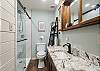 Second-floor bathroom featuring a walk-in shower and granite countertops