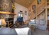 Living room with half round logs leading to the upstairs queen bedroom and loft