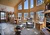 Open living room with fireplace, large windows perfect for your mountain vacation. 