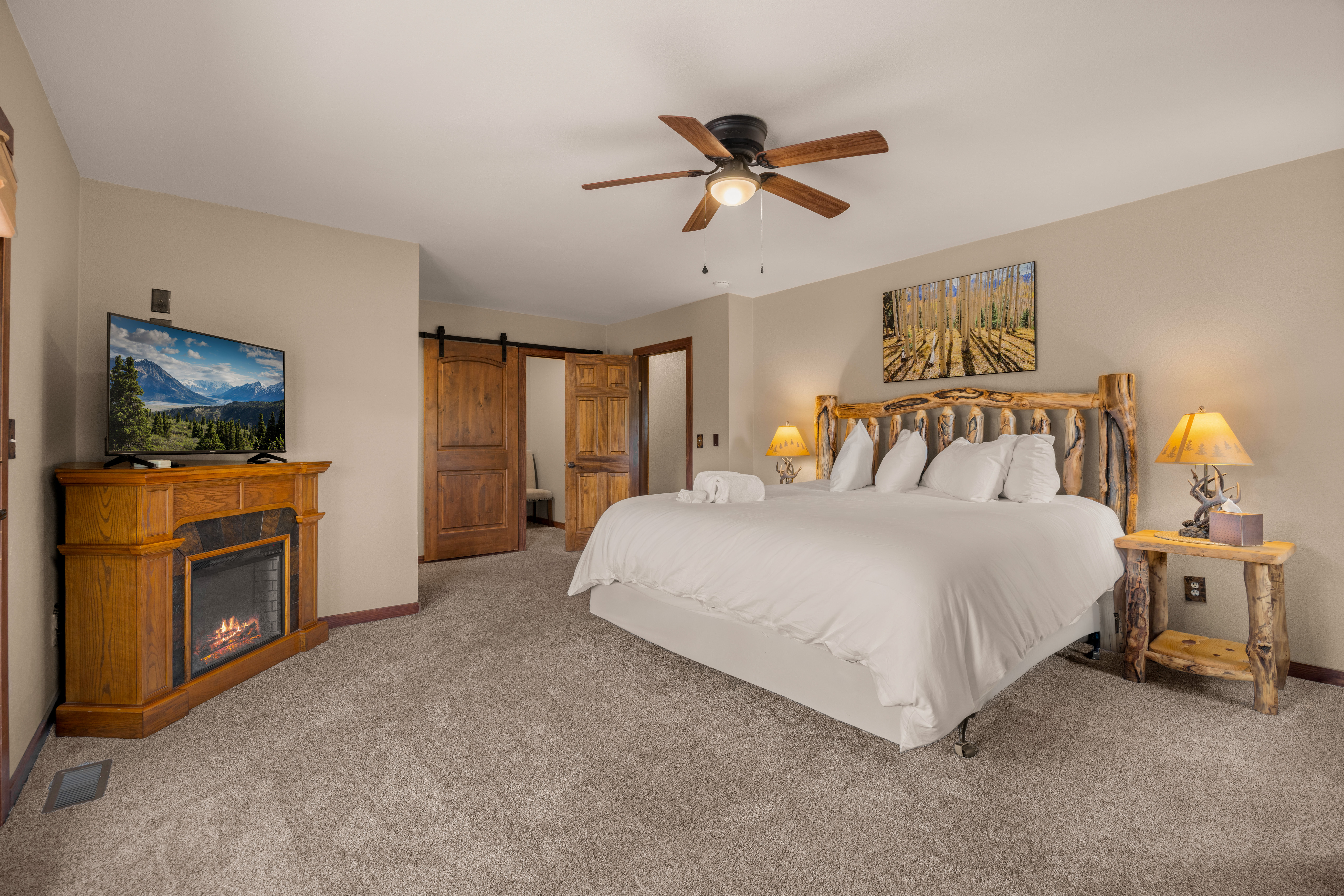 Primary Bedroom (Upper Level): King Bed with smart TV, private deck access, and an ensuite bathroom