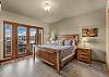 King bed in primary suite with deck access, mountain views