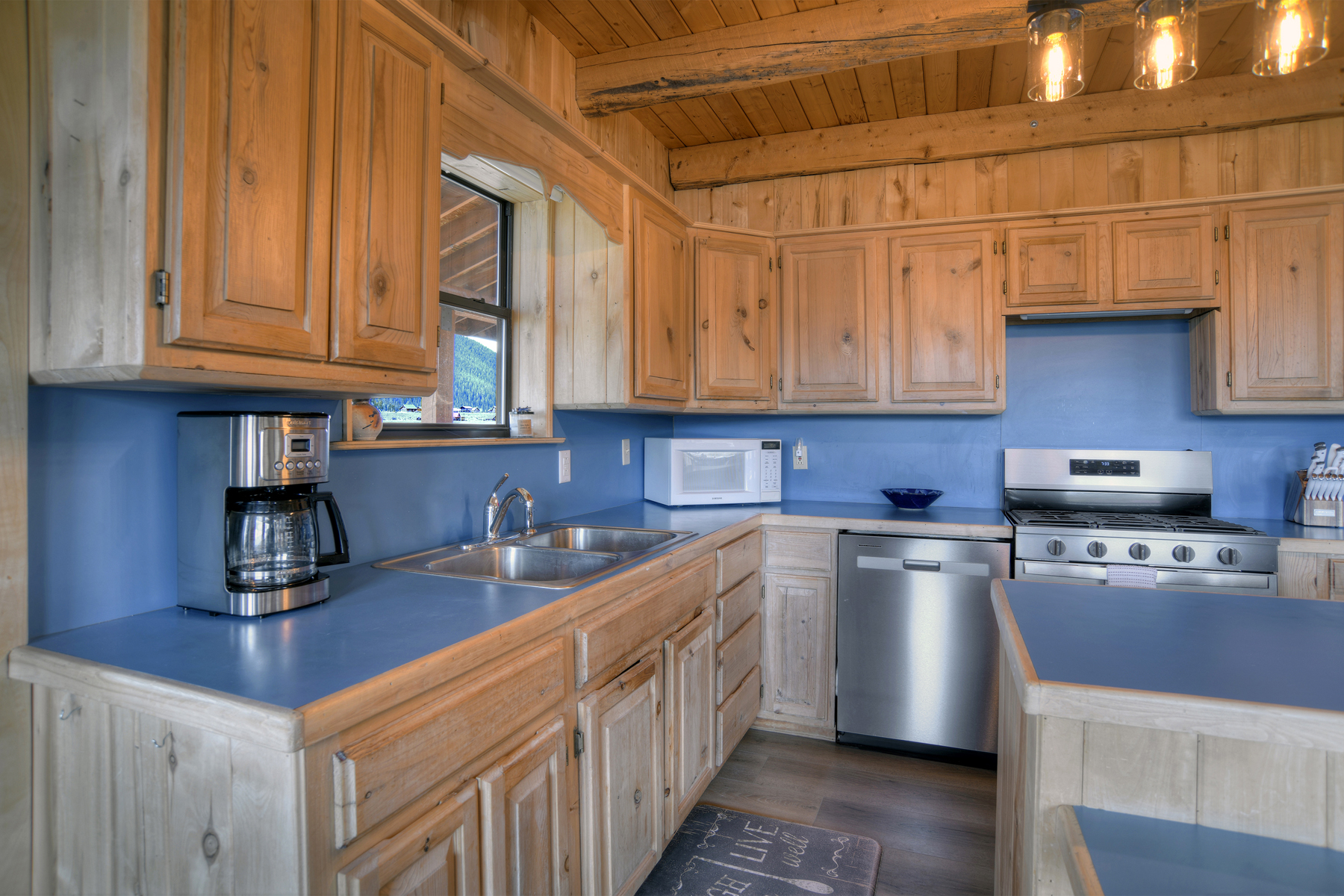 Open-concept living area featuring a fully equipped kitchen with stainless steel appliances, and a dining area with plenty of seating.