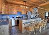 Fully equipped kitchen with stainless steel appliances, large prep area, and kitchen island with additional seating. 